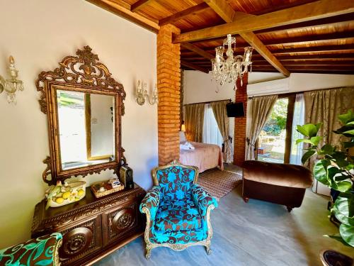 een slaapkamer met een spiegel, een stoel en een bed bij Segredo da Serra Guest House in Tiradentes