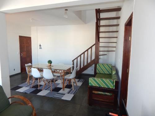 a dining room with a table and chairs and a staircase at Cobertura de 3 Quartos Duplex in Cabo Frio