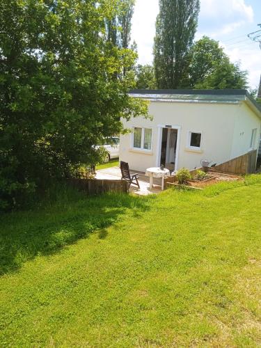 une maison blanche avec un banc dans une cour dans l'établissement La petite maison au calme dans les champs, à Matton-et-Clémency