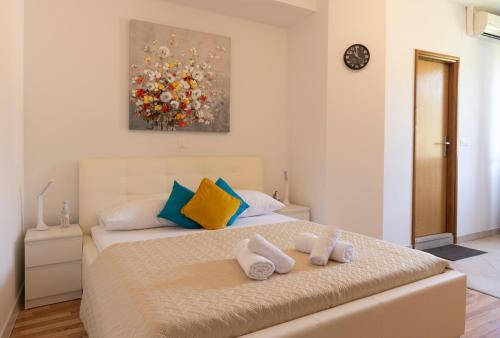 a bedroom with a bed with towels on it at Villa Violić in Zaton