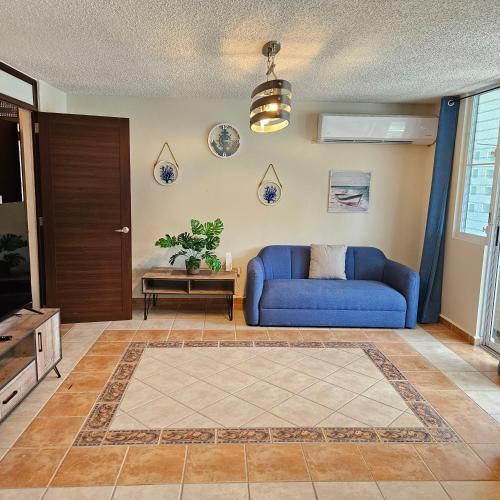 a living room with a blue couch and a table at Golden Dream Villas 1st floor A in Isabela