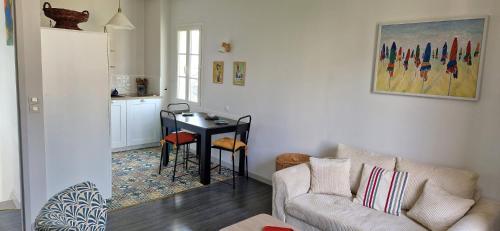 a living room with a couch and a table at Bel appartement, 2 chambres, Parking, proximité plage et centre ville in Trouville-sur-Mer
