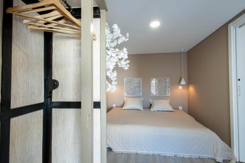un dormitorio con una cama con sábanas blancas en Birds Apartments, en Oporto