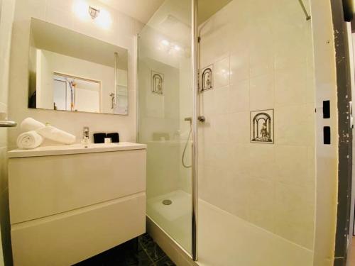 a white bathroom with a shower and a sink at 557 Cap Corniche Front de mer Clim Parking in Sète