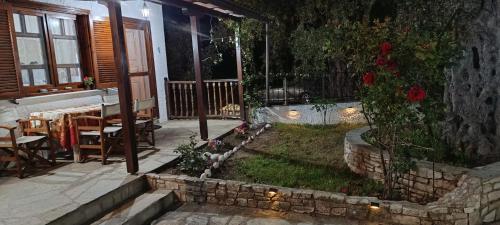 un patio con jardín con mesa y sillas en Villa Ioannis, en Skala Sotiros