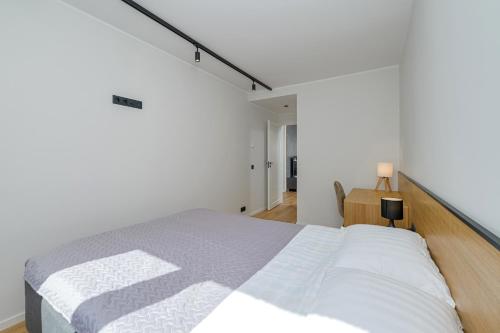 a bedroom with a large bed in a white room at New apartment near the airport, city center in Sikupilli in Tallinn