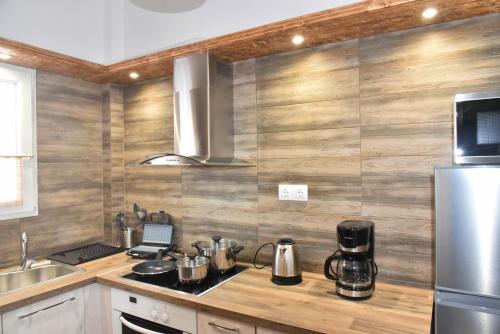 a kitchen with a counter with a stove and a refrigerator at F K Apartments in Artemida