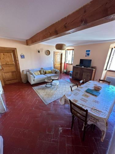 un salon avec une table et un canapé dans l'établissement Charmant T3 au cœur de la vieille ville, à LʼÎle-Rousse
