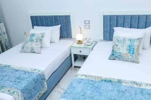 a bedroom with two beds and a night stand at Riviera tibarose in Marsa Matruh