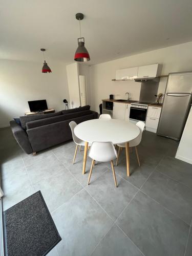 une cuisine et un salon avec une table et des chaises dans l'établissement Appartement neuf avec patio, à Saint-Laurent-sur-Sèvre
