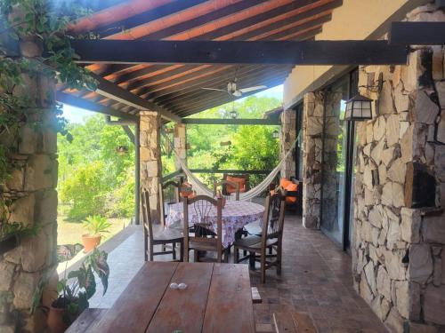 a patio with a table and chairs and a stone wall at La Soñada San Bernardino in San Bernardino