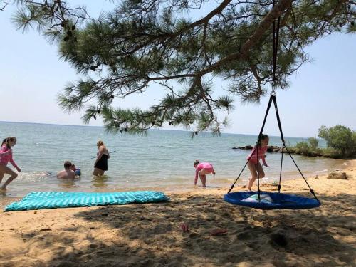 a group of people playing in the water at the beach at Tiny House at Piney point in Piney Point