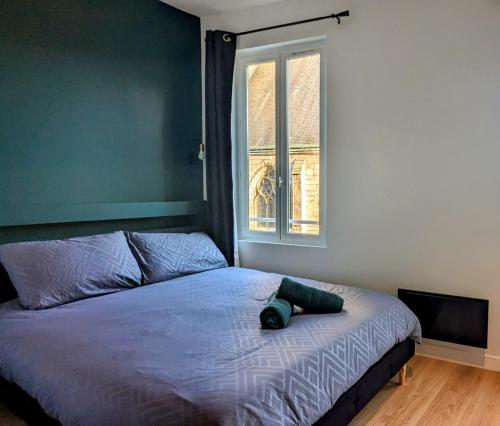 un lit dans une chambre avec une grande fenêtre dans l'établissement La Flèche Saint Vivien: Hypercentre & Cathédrale, à Rouen