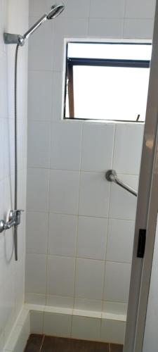 a bathroom with a shower with a glass door at Cabañas Rancho Pinares in Pichilemu