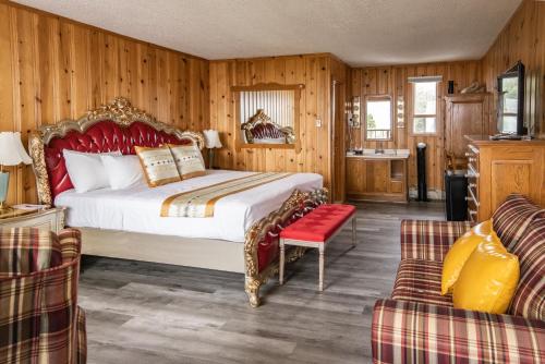 1 dormitorio con 1 cama, 2 sillas y sofá en Hotel La Roche Pleureuse en L'Isle-aux-Coudres