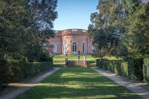a person walking down a path in front of a building at Douceur d'argile in Toulouse
