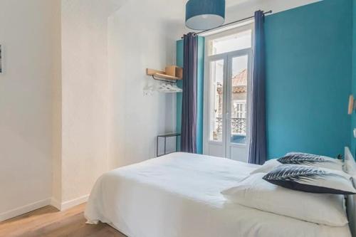 une chambre avec un lit blanc et une fenêtre dans l'établissement Longchamp - T2 - 10 min de St Charles, à Marseille