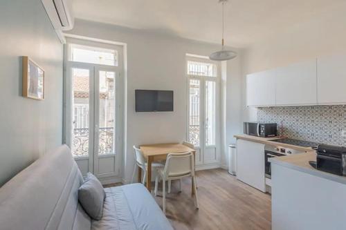 Il dispose d'une cuisine et d'un salon avec une table et un canapé. dans l'établissement Longchamp - T2 - 10 min de St Charles, à Marseille