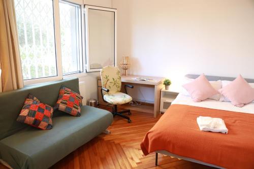 a bedroom with a bed and a couch and a desk at Alimos House in Athens