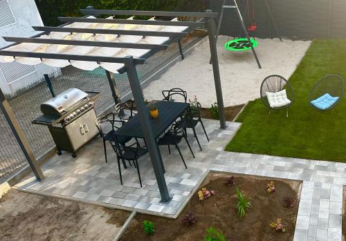 a patio with a table and chairs and a grill at Pokoje Dziwnów Welle in Dziwnów