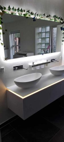 a bathroom with two sinks and a large mirror at The Dream Villa in Rødby