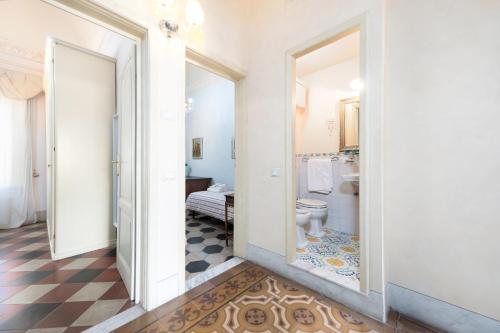a hallway with a bathroom with a toilet and a mirror at Villa Lola - Liberty Dreamscape in Viareggio