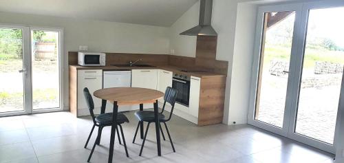 - une cuisine avec une table et des chaises en bois dans la chambre dans l'établissement Studio Pic au vert, à Martigné-Ferchaud