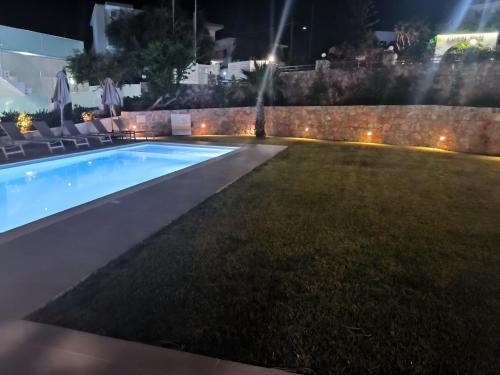 a swimming pool in a yard at night at Cost Mari Almyrida New by ZAGO Boutiqe hotels in Almirida