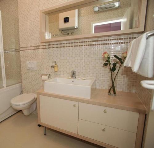 a bathroom with a sink and a toilet and a mirror at Villa Queen in Trogir