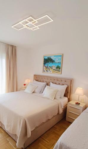 een slaapkamer met een groot bed met witte lakens bij Villa Queen in Trogir
