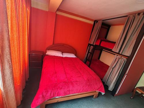 - une chambre avec 2 lits superposés et des murs rouges dans l'établissement Yati Hostal, à La Paz