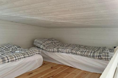 two beds sitting in a room with a wall at Gästhus i Nacka in Boo