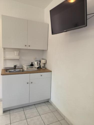 a kitchen with white cabinets and a sink at Cost Mari Almyrida New by ZAGO Boutiqe hotels in Almirida