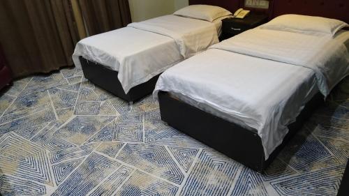 two beds sitting next to each other in a room at عرعر Desert Rose Hotel in Arar