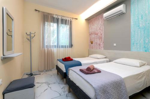 Una habitación de hospital con dos camas y una ventana. en Villa Rafaella2, en Koskinou
