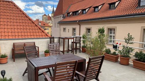 a patio with tables and chairs on a balcony at Anenska by Charles Bridge 3 in Prague