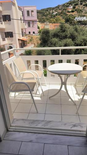 a patio with a table and chairs on a balcony at Cost Mari Almyrida New by ZAGO Boutiqe hotels in Almirida