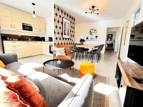 een woonkamer met een bank en een tafel bij Disney Ratatouille Paris 5mn park & Val d'Europe in Chessy