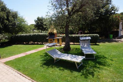 two chairs and a table in a yard at Rosanna House in Bombarde Beach in Alghero