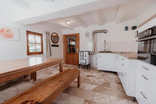 a kitchen with white cabinets and a wooden table at Ferienhaus am HerbstHof in Leutschach