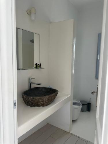 a bathroom with a stone sink and a mirror at ENE’S Mýkonos in Klouvas