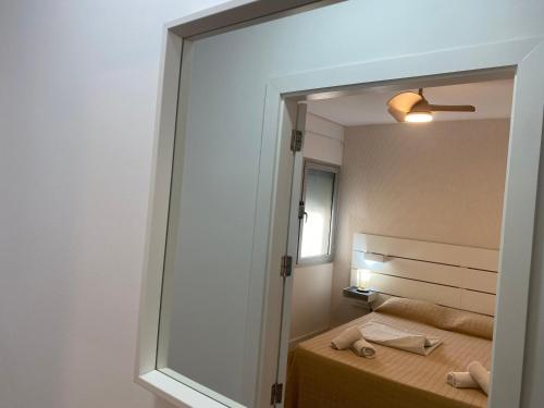 een grote spiegel in een kamer met een bed en een bed bij El Rincón de Valentina 4B in Las Palmas de Gran Canaria