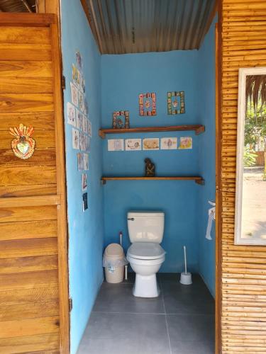a bathroom with a toilet in a blue wall at Camping Babsita in Tuba Creek