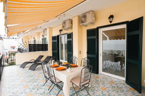 a patio with a table and chairs on a balcony at Ammore Ammare Apartment in Ischia