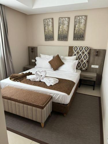 Un dormitorio con una cama grande con una flor. en Appartments VIP Al Hoceima Sfiha en Alhucemas