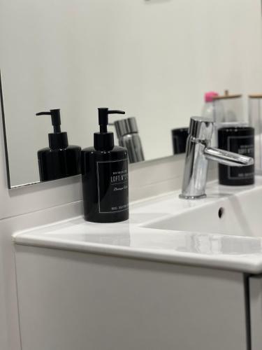 a bathroom sink with a bottle of soap and a mirror at Domus Vallis - Modern house in Furnas in Furnas