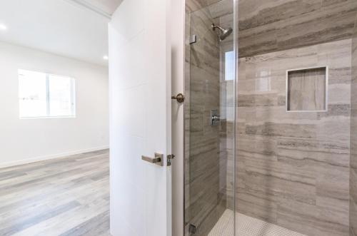 a shower with a glass door in a room at Ktown Homestay in Los Angeles