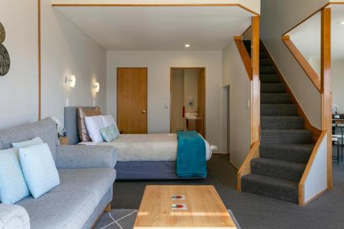 a hotel room with a bed and a staircase at Cascades Lakefront Motel in Taupo