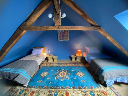two beds in a room with a blue ceiling at la petite maison Normandie in Saint-Cyr-du-Bailleul
