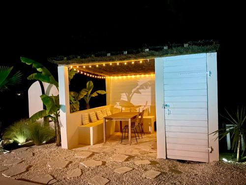 um pequeno barracão com uma mesa, cadeiras e luzes em Maison d'exception Girondine em La Lande-de-Fronsac